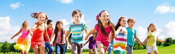 group of children running outside in a field